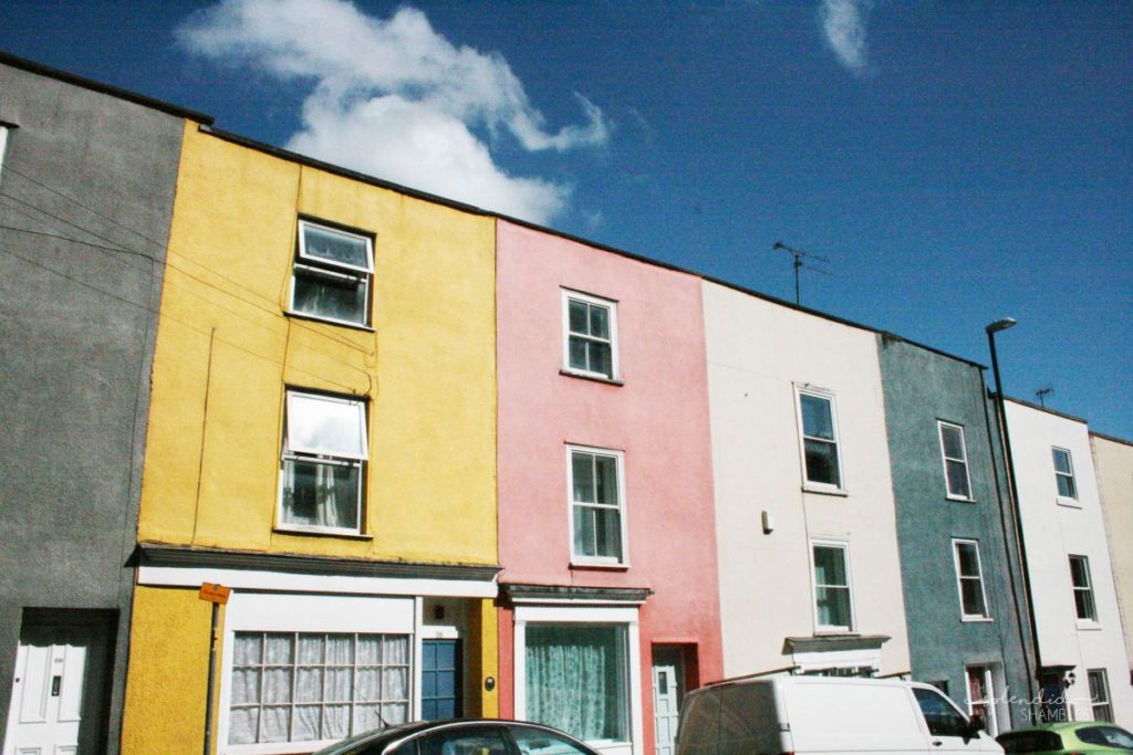 Row of colorful townhouses with flat roofs. How to spend a day in Bristol, England. This Splendid Shambles.