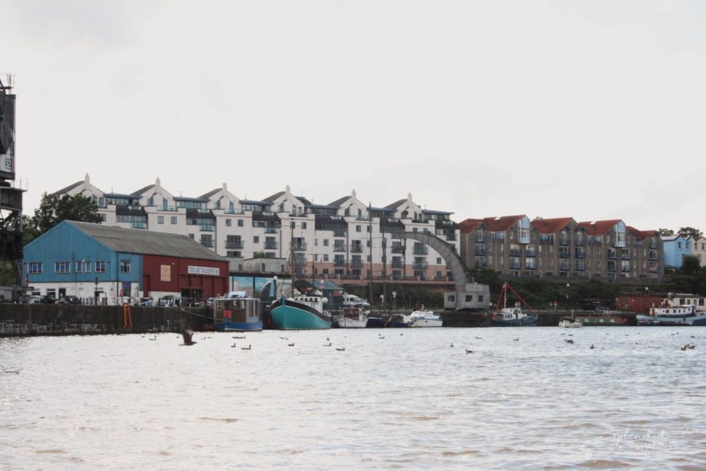 River in the foreground, ubldings on the opposite banks. How to spend a day in Bristol, England. This Splendid Shambles. 