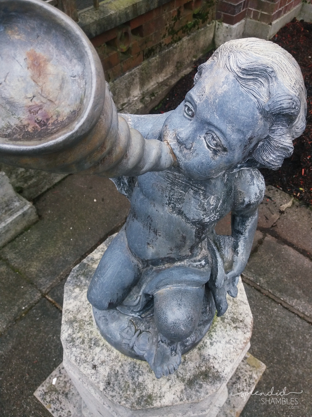 Top down view of a sculpture at the Auckland Wintergardens. The sculpture is of a child playing a horn pipe.