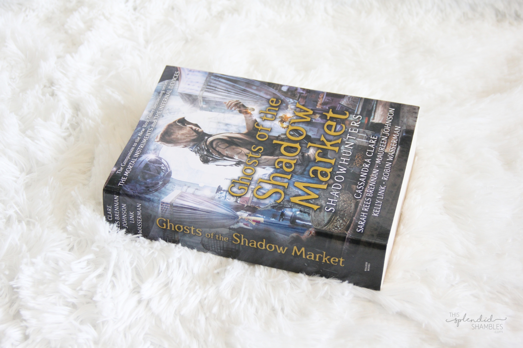 Ghosts of the Shadowmarket by Cassandra Clare on a white fluffy blanket