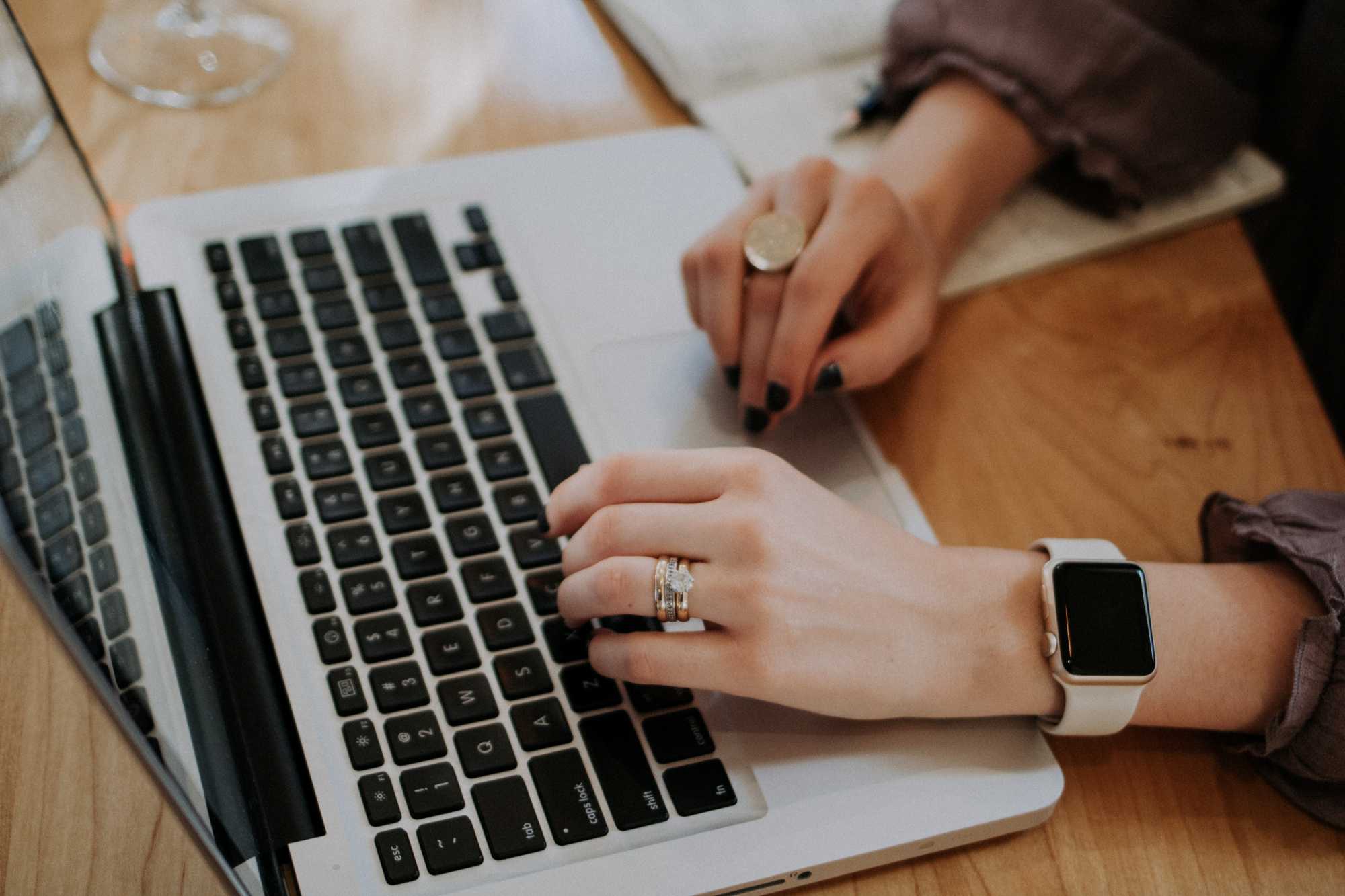 Woman's hands typing on a silver laptop - how to write productivity at home and avoid burnout