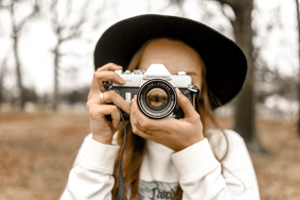 Close up of a woman with a camera. The Difference between JPGs and PNGs.