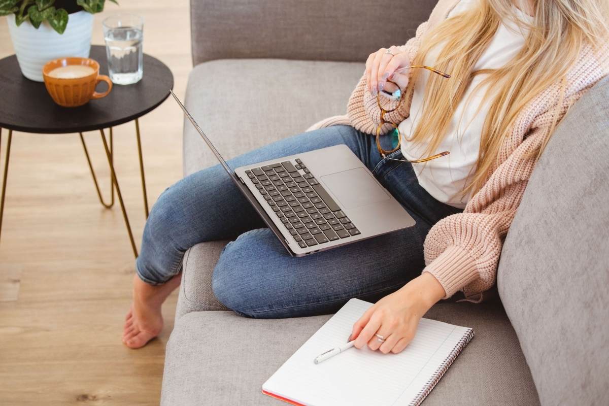 Woman sitting on a coach with a laptop on her knee. 6 tips on content creation for social media on This Splendid Shambles.