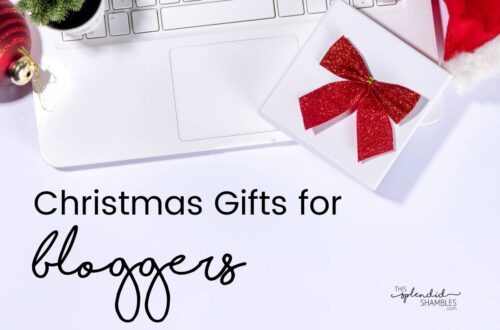 White table with a white laptop and white presents with red bows. 'Christmas gifts for bloggers' written on the left in black.