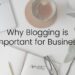 Flat lay of a desk with laptop in top left hand corner, cup of coffee at the top, open notebook with pencil and glasses at the bottom. Words 'Why Blogging is Important For Business' written over the top.