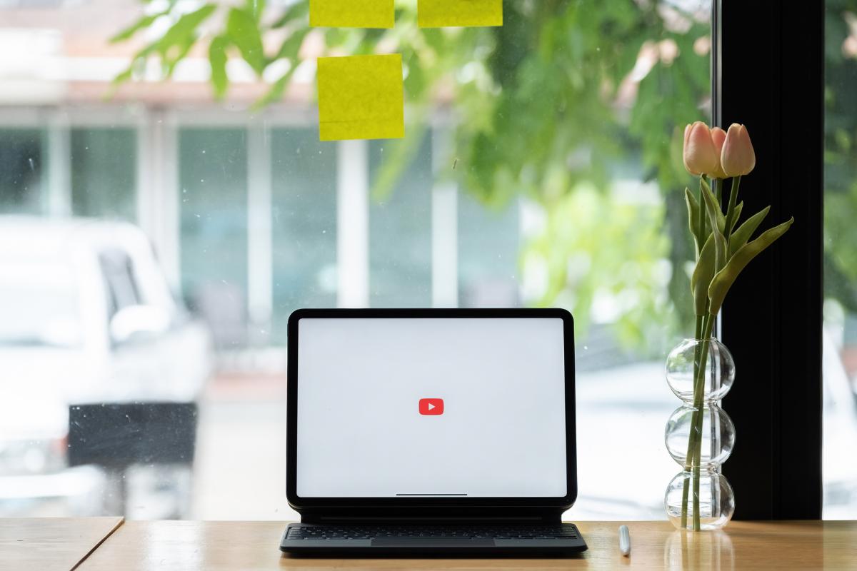 Open laptop showing YouTube on a table.