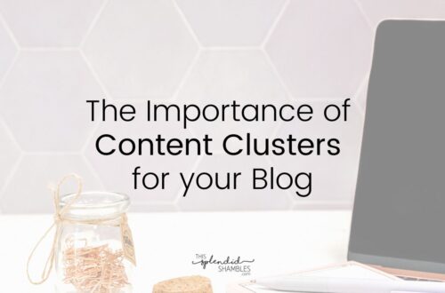 Laptop on the right of the image, sitting on a white table, various stationery items to the left. 'The Importance of Content Clusters for your blog' written on top.