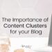 Laptop on the right of the image, sitting on a white table, various stationery items to the left. 'The Importance of Content Clusters for your blog' written on top.